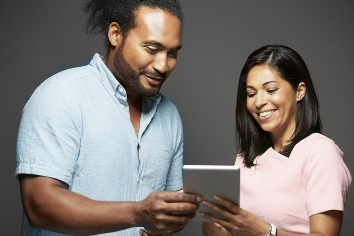 Two Australian adults sharing advert on digital tablet